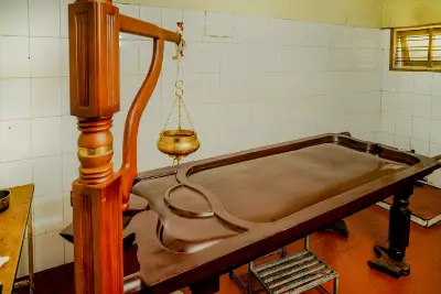 Traditional Ayurvedic treatment table (droni) in a therapy room